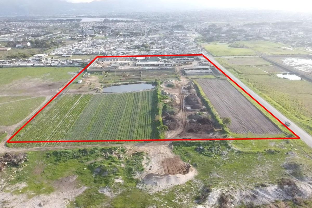 Aerial view of a large farm property featuring cultivated fields, an irrigation pond, and clear boundary demarcation.