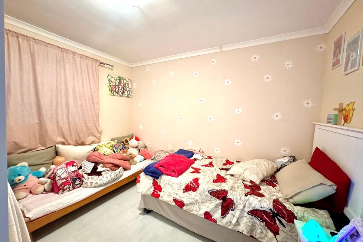A bedroom featuring laminate flooring and coving, currently utilized as a child's room with decorative wall decals.