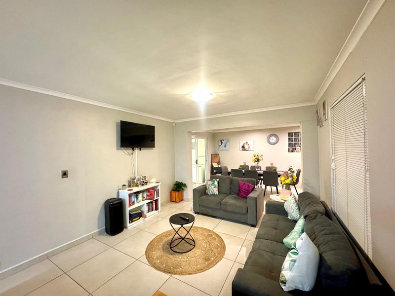 Open plan living and dining area featuring neutral wall tones, tiled flooring, and coved ceilings, providing a functional and connected living space.