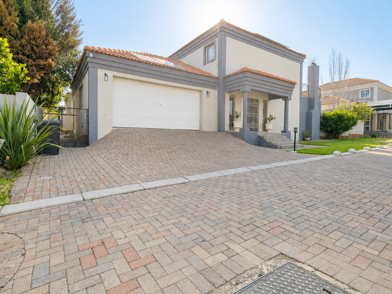 Front elevation of a two-story house featuring a paved driveway, double garage, and tiled roof architecture.