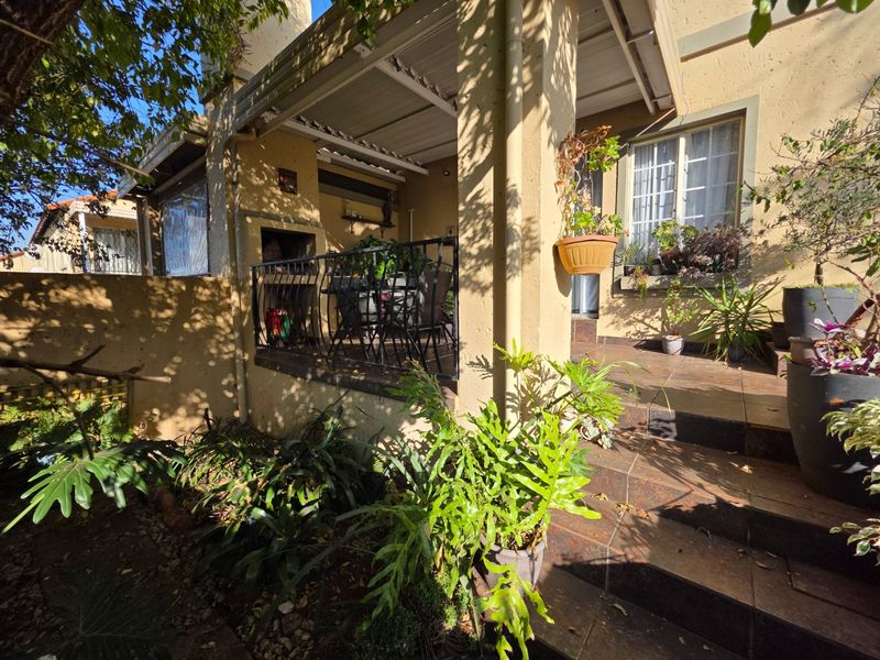 A covered patio area featuring a built-in braai, tiled flooring, and wrought iron railings, providing a functional outdoor entertainment space.