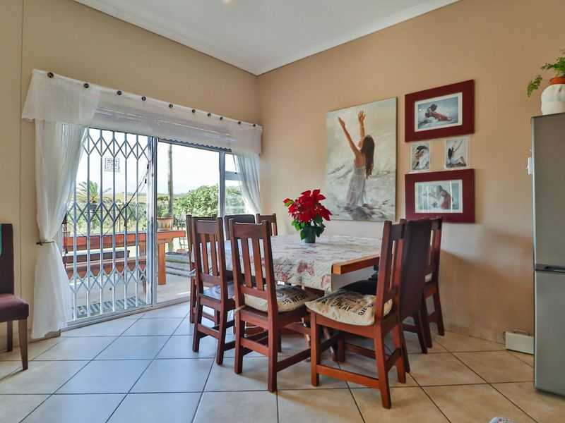 A dining area featuring tiled flooring and a sliding glass door with a security gate, providing direct access to the outdoor patio.