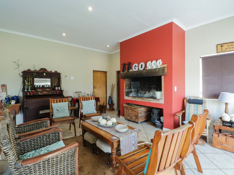 A cozy living room featuring a prominent red-painted built-in fireplace and neutral tiled flooring, offering a warm and inviting atmosphere.
