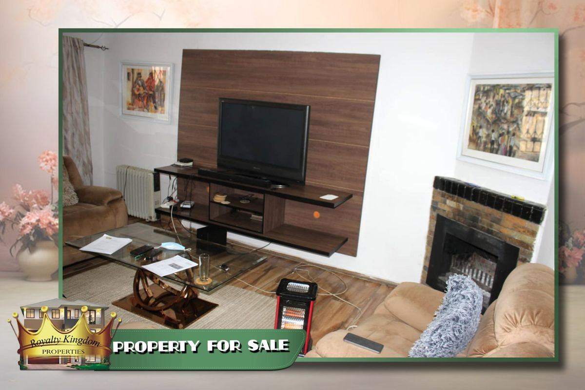 Living room featuring a built-in media wall unit and a traditional brick fireplace with a tiled hearth.