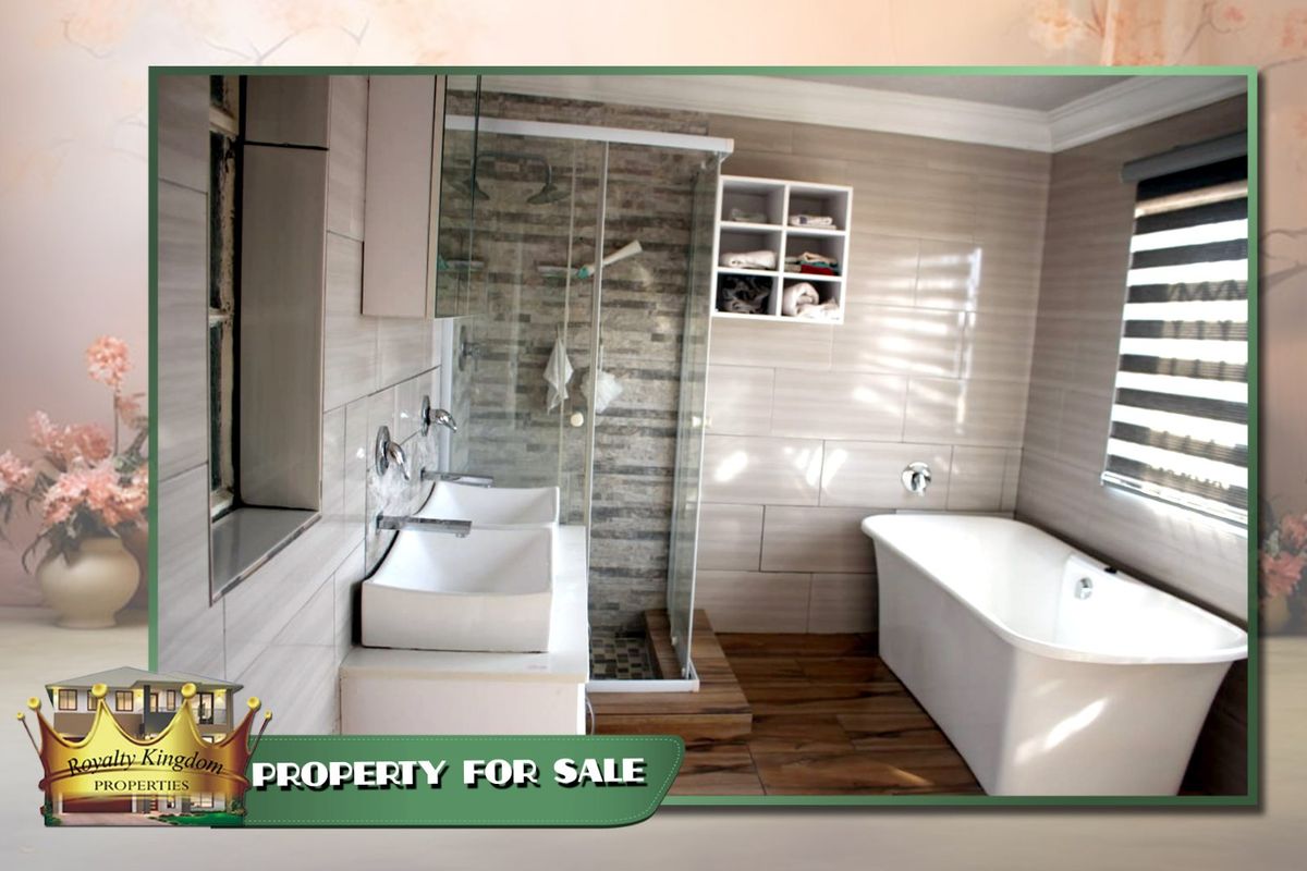 Modern bathroom featuring a freestanding bathtub, glass-enclosed shower, double vanity with wall-mounted faucets, and contemporary tiled finishes.