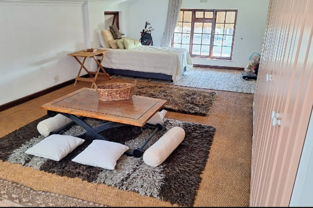 Spacious bedroom featuring built-in cupboards, timber-framed windows, and neutral wall finishes, offering a versatile layout with ample natural light.