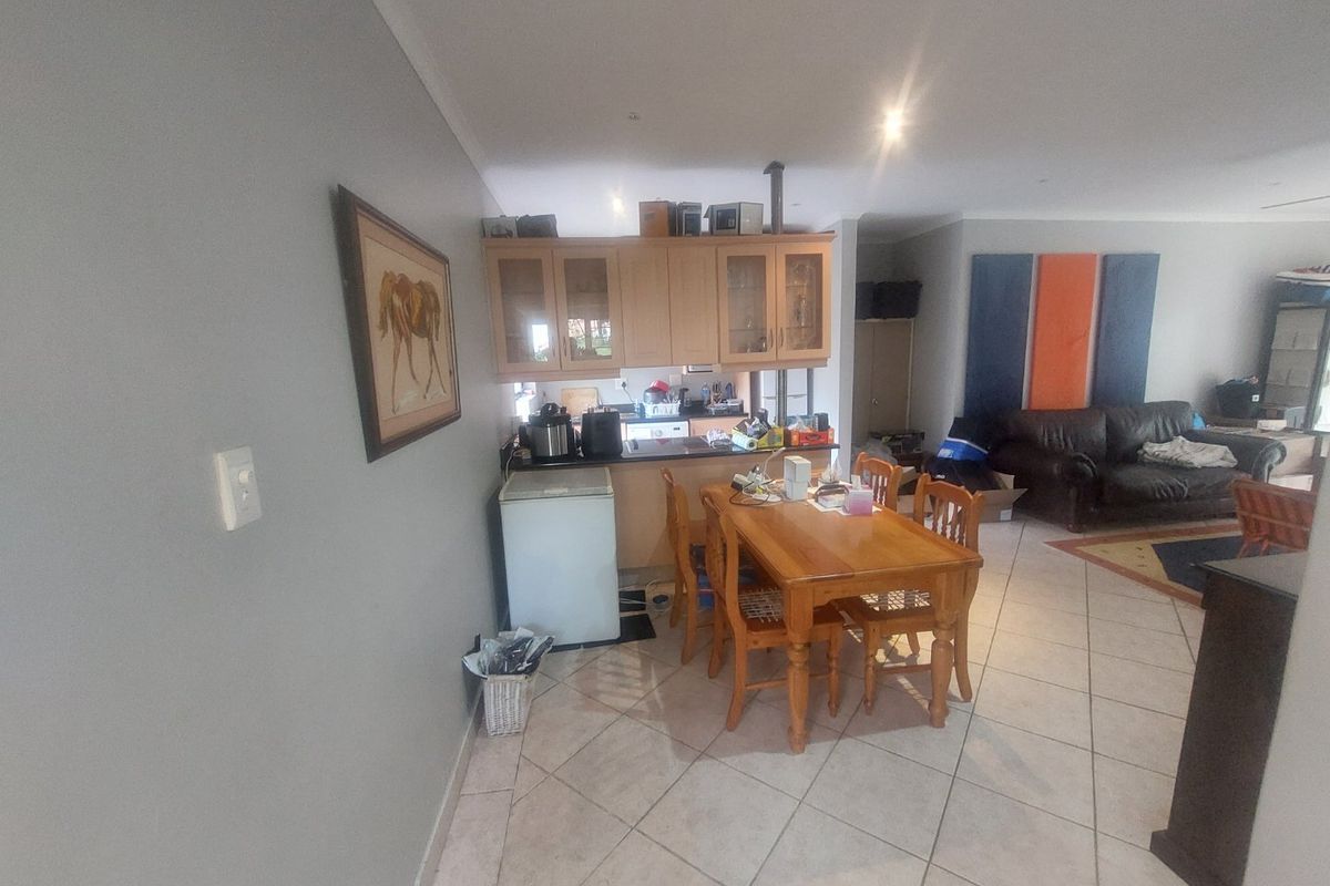 Open plan living and dining area featuring tiled flooring and integrated kitchen cabinetry, providing a functional layout for daily living.