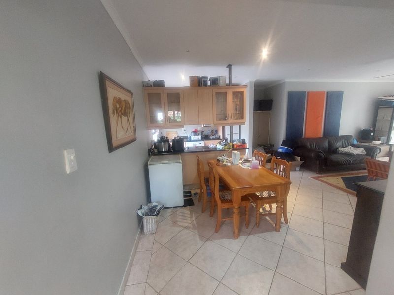 Open plan living and dining area featuring tiled flooring and integrated kitchen cabinetry, providing a functional layout for daily living.