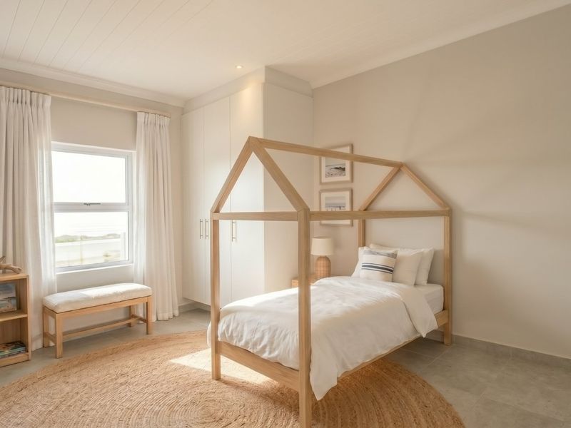 A bright and well-maintained bedroom featuring neutral tones, built-in cupboards, tiled flooring, and a classic tongue and groove ceiling.