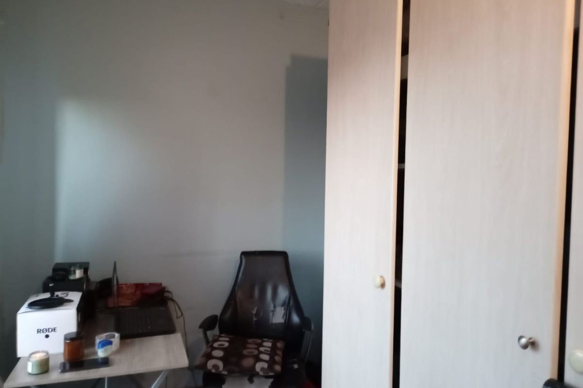 A bedroom featuring a built-in wardrobe with light wood-finish doors.