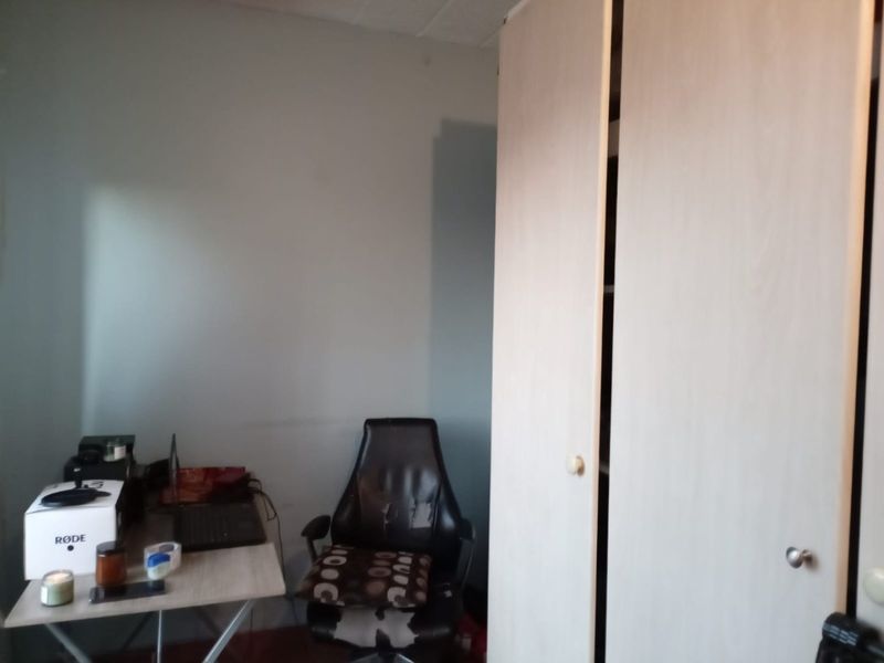 A bedroom featuring a built-in wardrobe with light wood-finish doors.