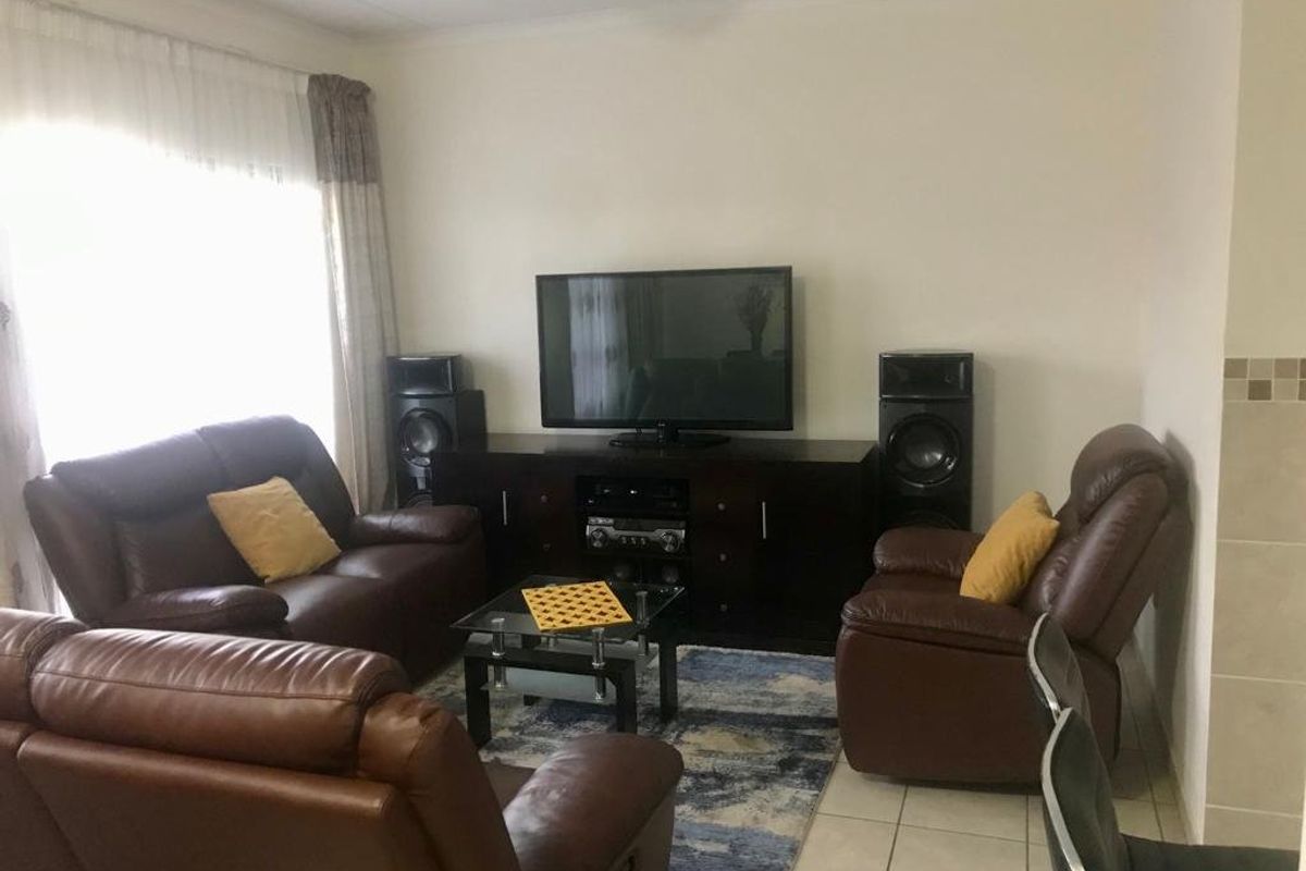 A comfortable living room featuring tiled flooring and neutral wall finishes, providing a functional space for relaxation and entertainment.