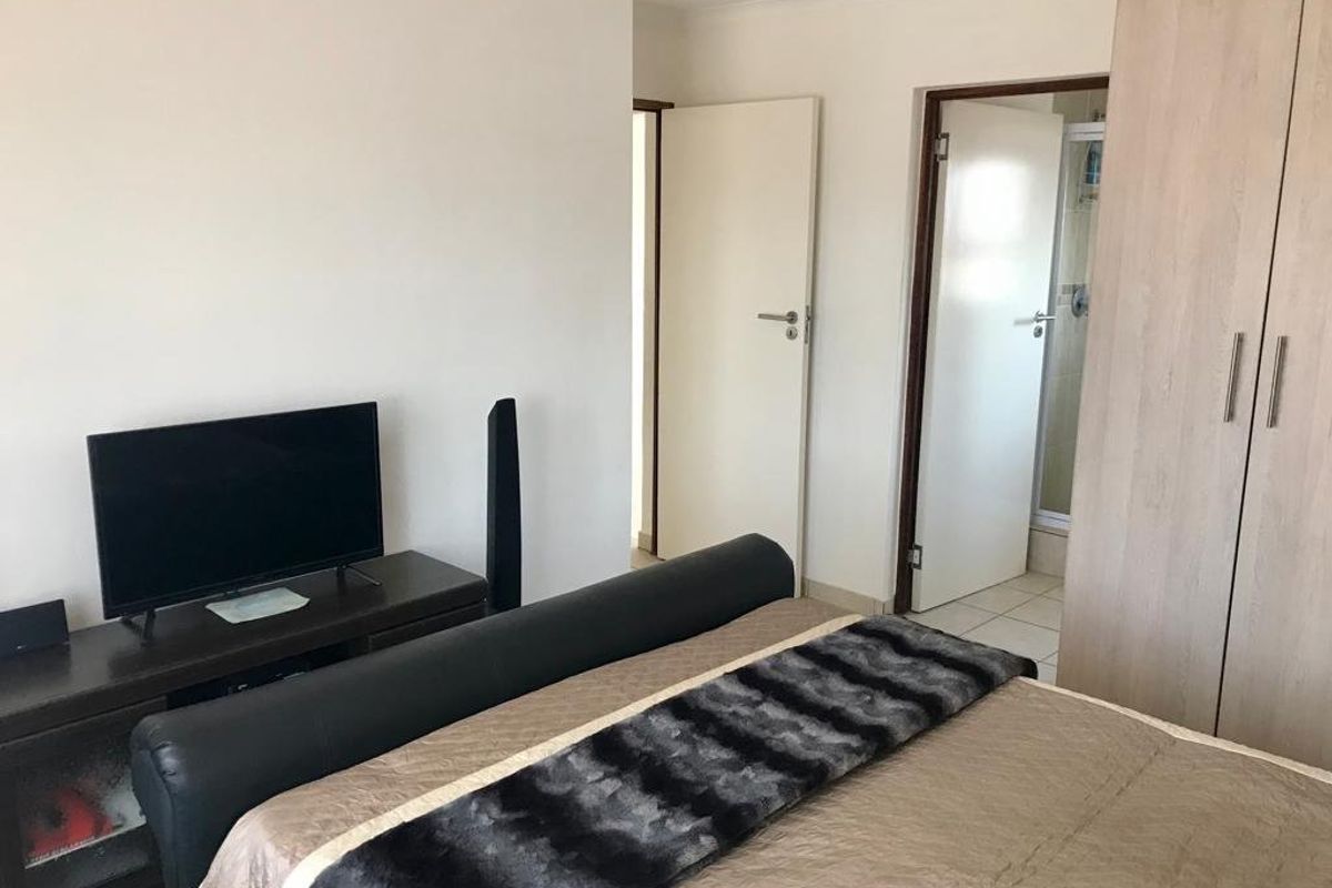 A functional bedroom featuring built-in wardrobes and direct access to an en-suite bathroom.