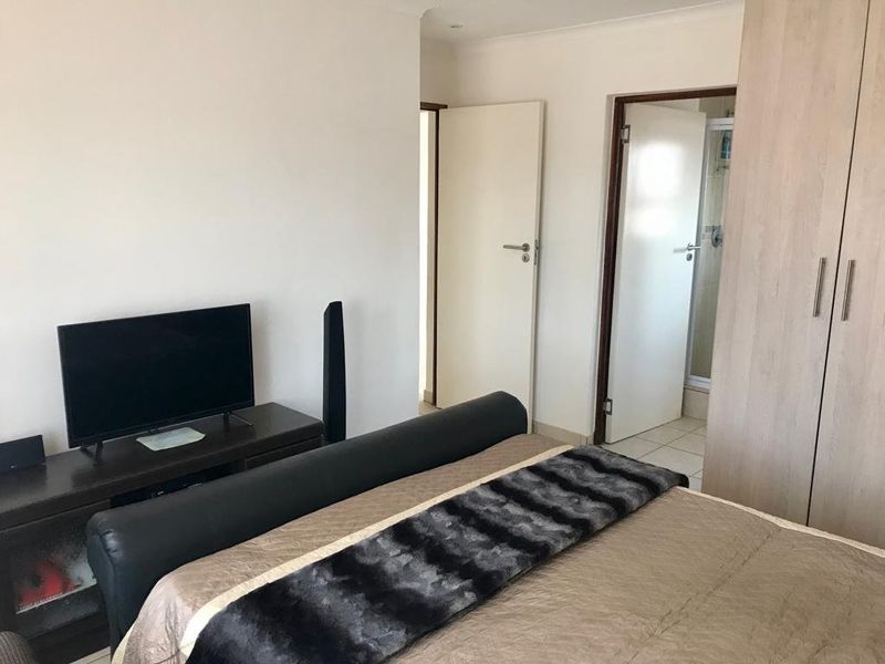 A functional bedroom featuring built-in wardrobes and direct access to an en-suite bathroom.
