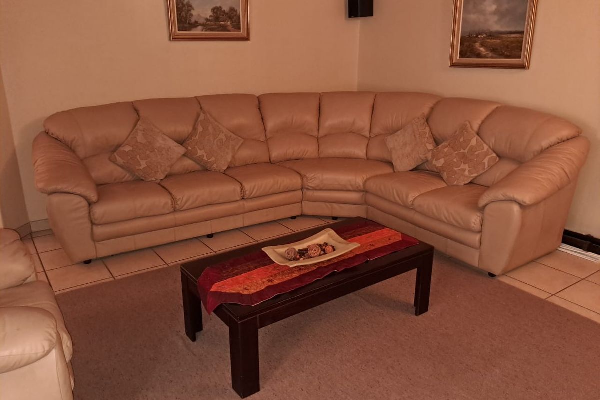 A comfortable living room area featuring neutral ceramic floor tiles and a spacious layout suitable for family relaxation.