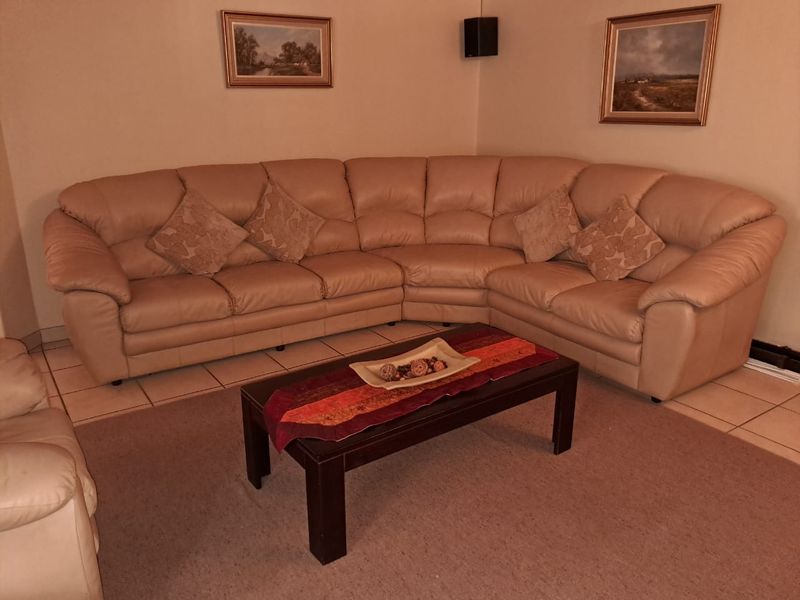 A comfortable living room area featuring neutral ceramic floor tiles and a spacious layout suitable for family relaxation.