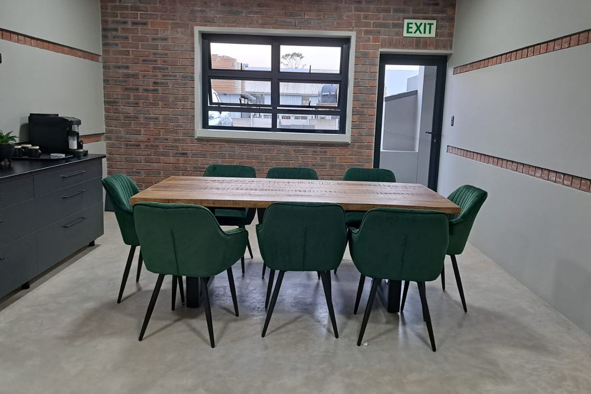 A modern commercial office space featuring an exposed brick feature wall, polished concrete flooring, and built-in storage cabinetry.