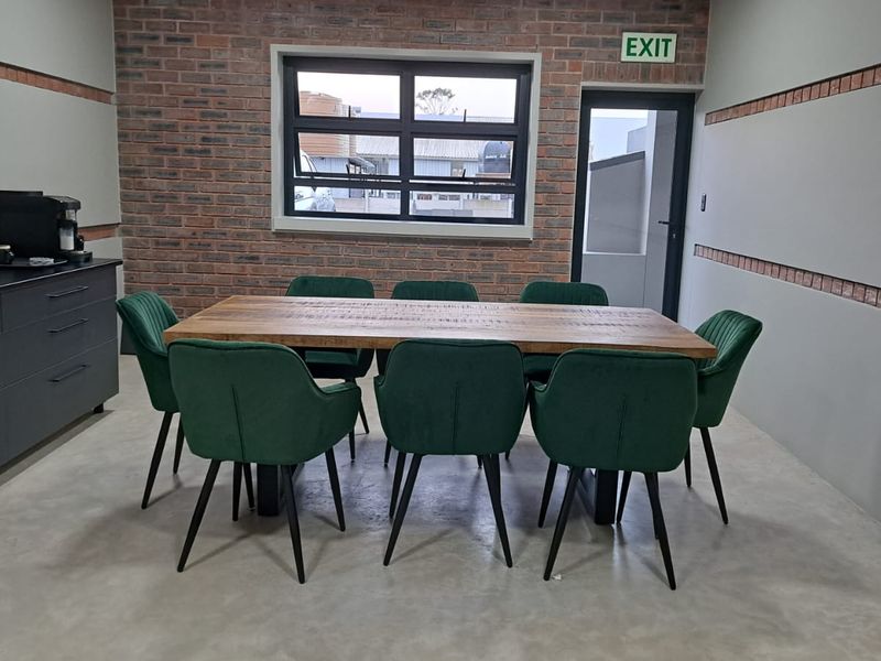 A modern commercial office space featuring an exposed brick feature wall, polished concrete flooring, and built-in storage cabinetry.