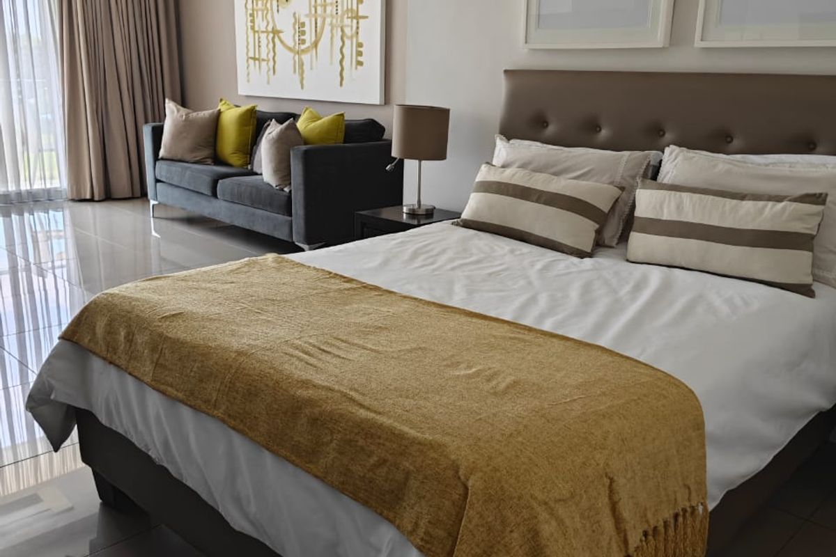 A well-maintained bedroom featuring polished tiled flooring, recessed ceiling lighting, and floor-to-ceiling curtains, creating a bright and modern living space.