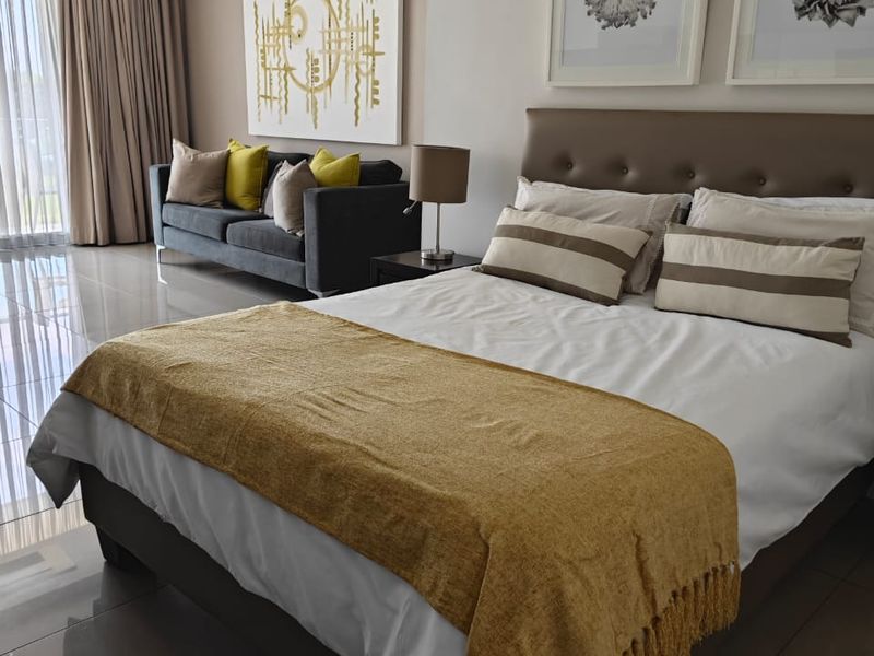 A well-maintained bedroom featuring polished tiled flooring, recessed ceiling lighting, and floor-to-ceiling curtains, creating a bright and modern living space.