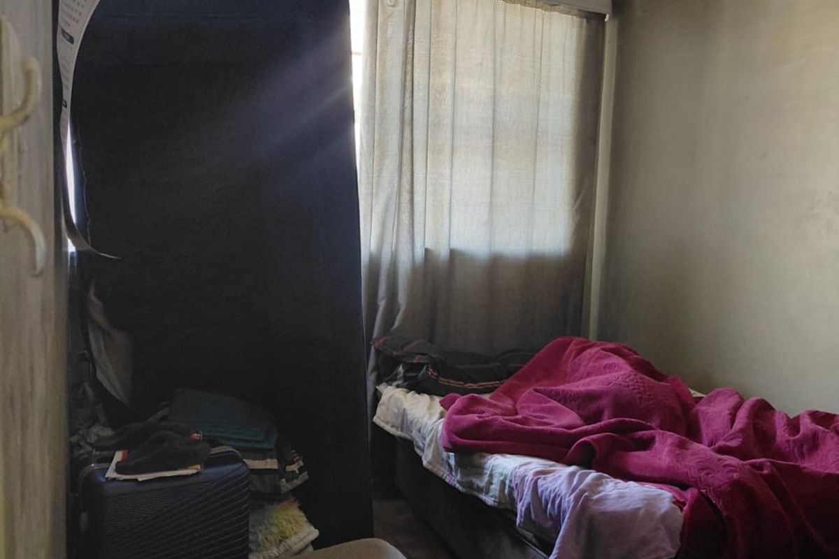 A bedroom space featuring tiled flooring and window treatments, currently showing significant signs of ceiling deterioration and moisture damage.