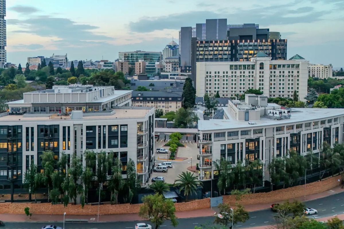 Aerial view of a modern commercial office complex featuring multiple buildings, paved parking facilities, and surrounding urban infrastructure.