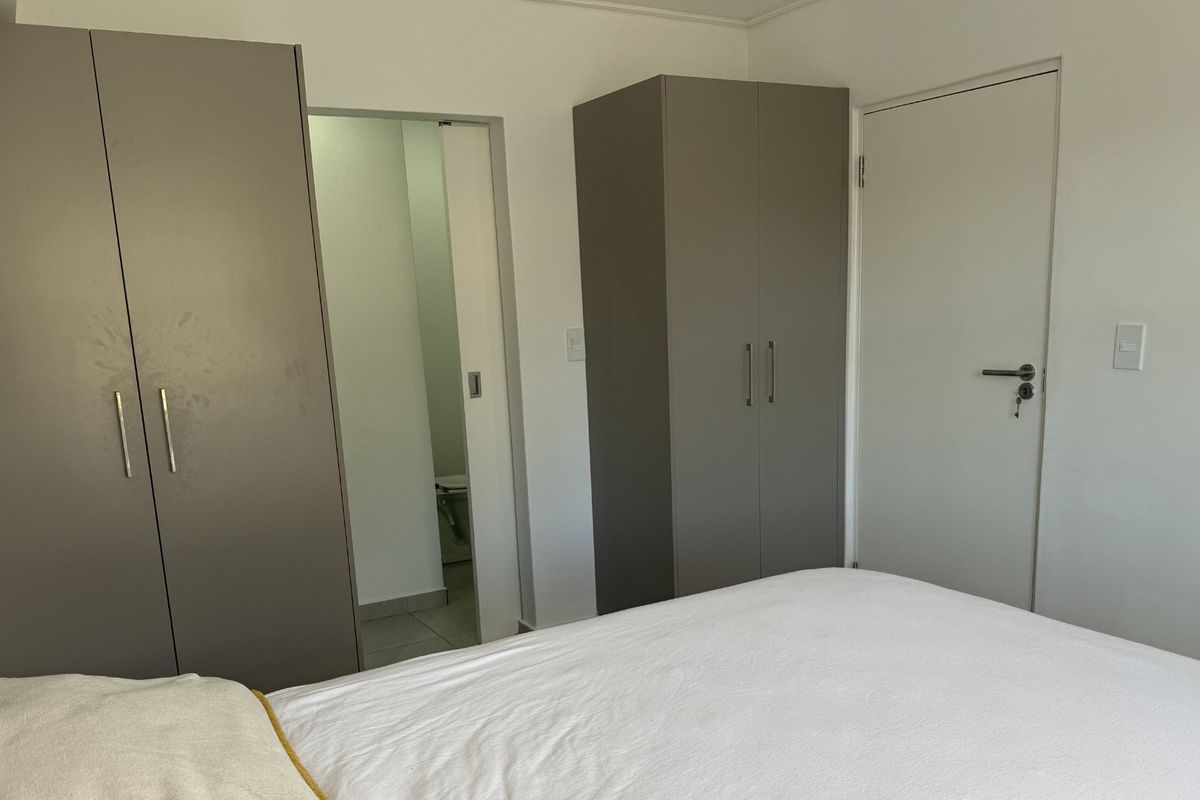 A bedroom featuring built-in cupboards and direct access to an adjoining bathroom.