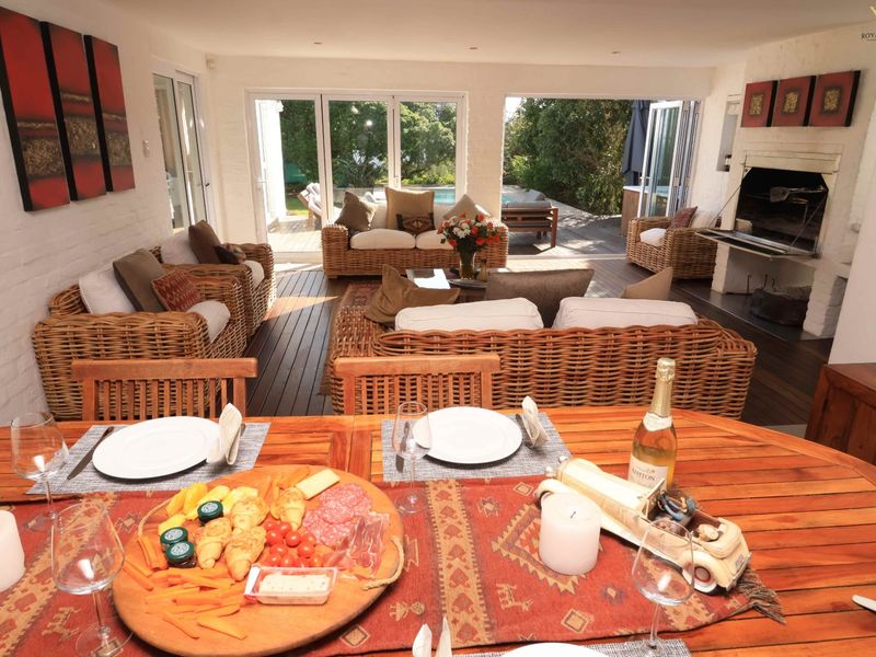 Spacious open-plan living and dining area featuring a built-in fireplace, timber flooring, and seamless flow to the outdoor patio through large bi-fold doors.