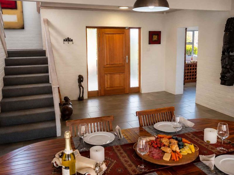 Welcoming entrance hall featuring tiled flooring, a timber front door with side glass panels, and a carpeted staircase leading to the upper level.