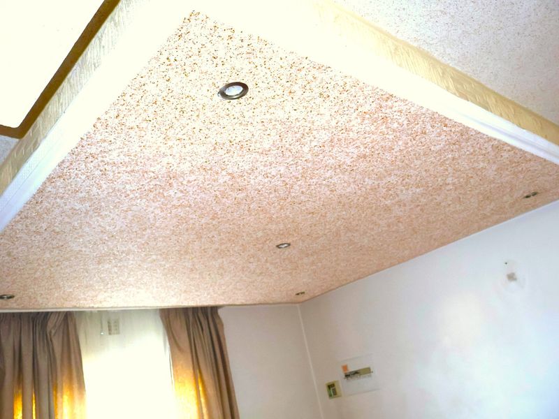 A close-up view of a textured ceiling feature with integrated recessed downlights.
