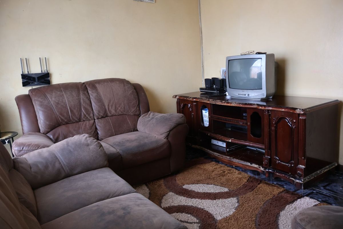 A living room space featuring plain wall finishes and visible surface-mounted electrical wiring.