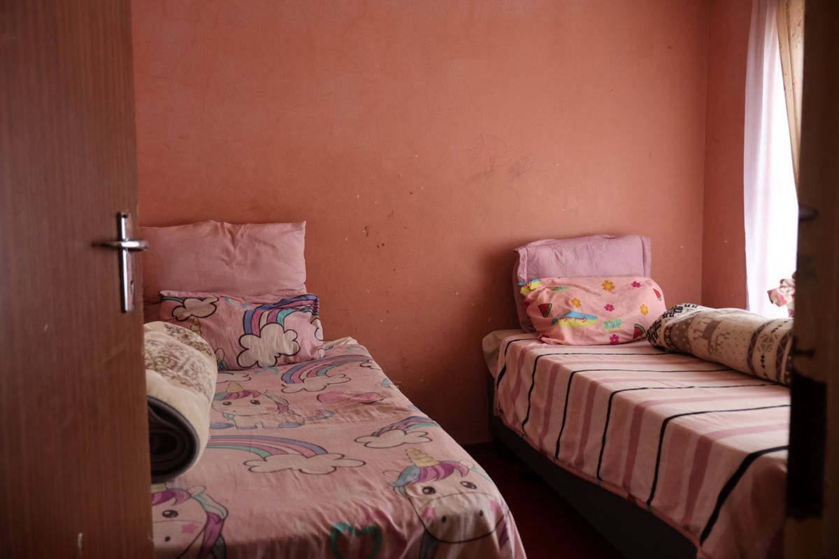 A bedroom featuring painted walls and an internal door, currently set up with twin beds.