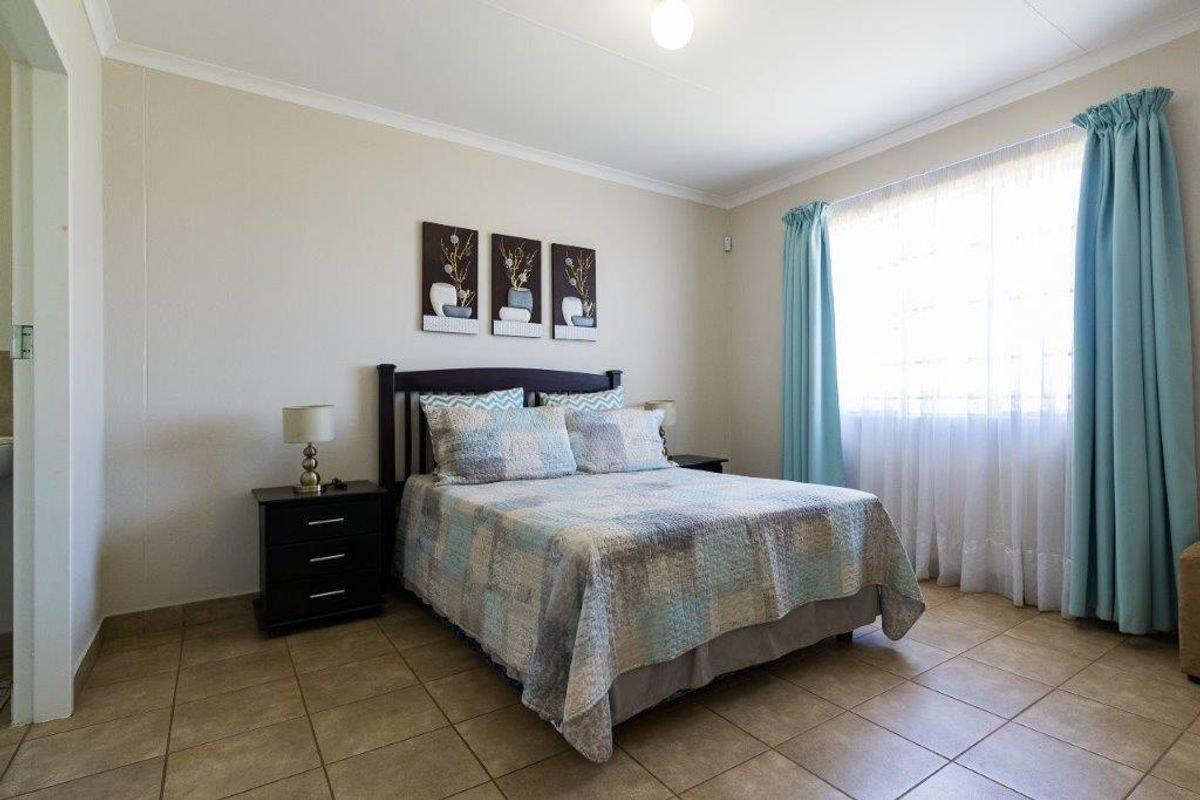 A well-lit bedroom featuring neutral wall finishes and durable tiled flooring, providing a comfortable and functional living space.