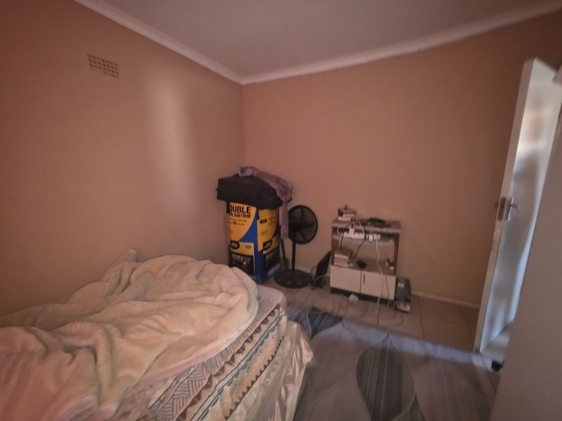 A bedroom featuring tiled flooring and neutral wall paint, providing a functional space ready for personalization and updated interior design.