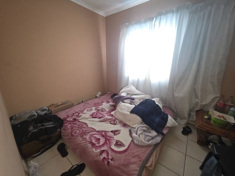 A bedroom featuring tiled flooring and coving, currently requiring cosmetic updates to improve its overall presentation and appeal.