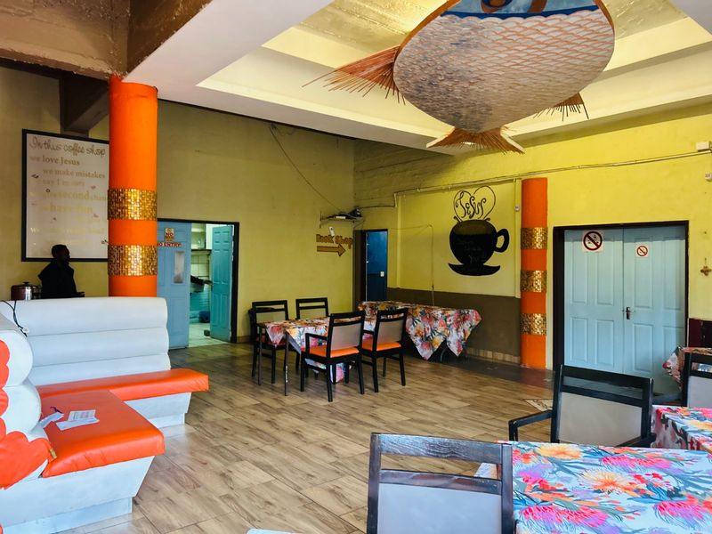 Open plan commercial space featuring built-in seating, decorative columns, and tiled flooring, suitable for a cafe or retail environment.