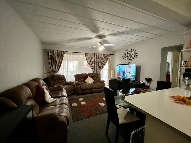 Open plan living and dining area featuring a ceiling fan, tiled ceiling, and direct access to an outdoor space through sliding glass doors.