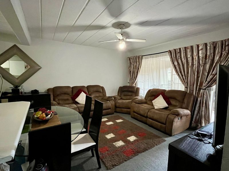 Open plan living and dining area featuring a ceiling fan, tongue and groove ceiling, and sliding glass door access to the exterior.