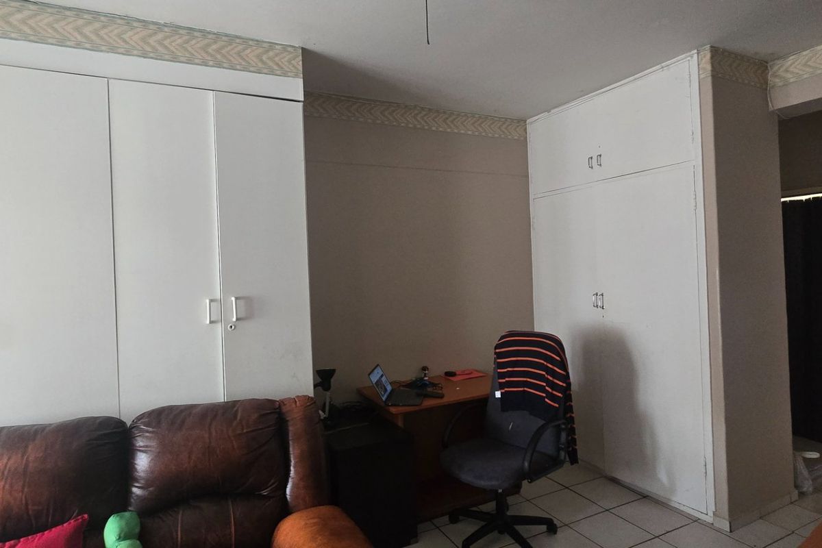 Bedroom featuring extensive built-in cupboard storage, tiled flooring, and decorative cornice detailing.