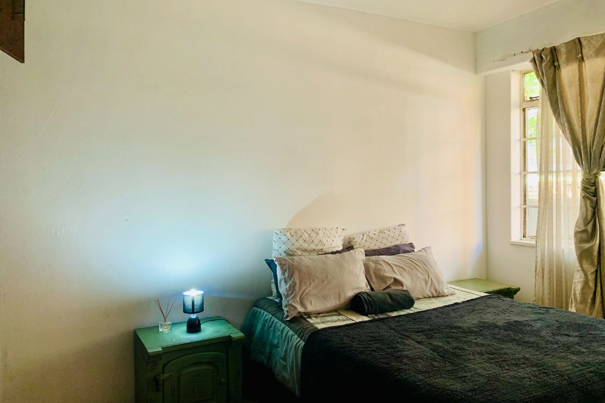 A simple bedroom featuring a window with curtains, providing natural light and a neutral space ready for personalization.