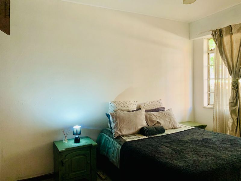 A simple bedroom featuring a window with curtains, providing natural light and a neutral space ready for personalization.