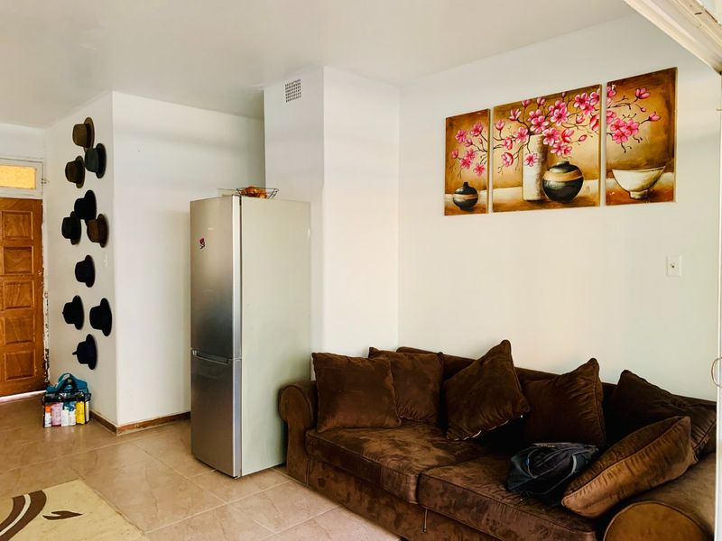 A living area featuring tiled flooring and a neutral wall finish, providing a functional space for relaxation.