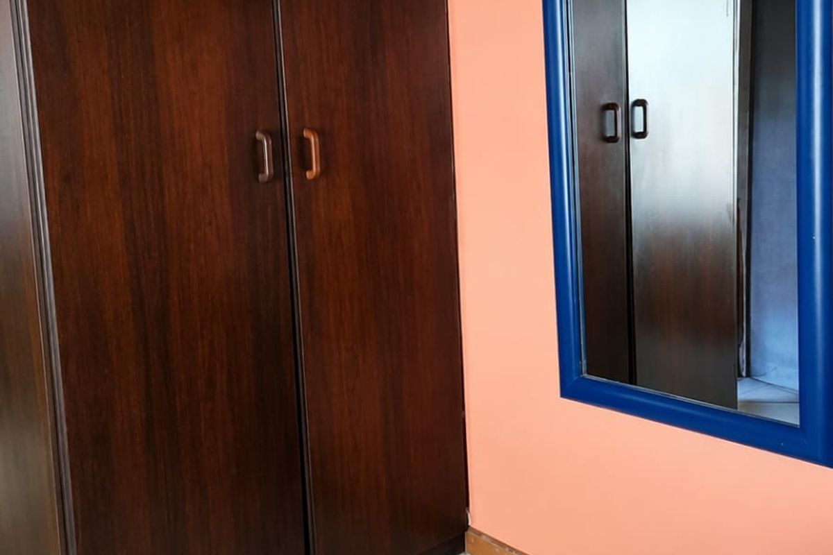 Bedroom featuring built-in dark wood cabinetry, wooden ceiling paneling, and tiled flooring.
