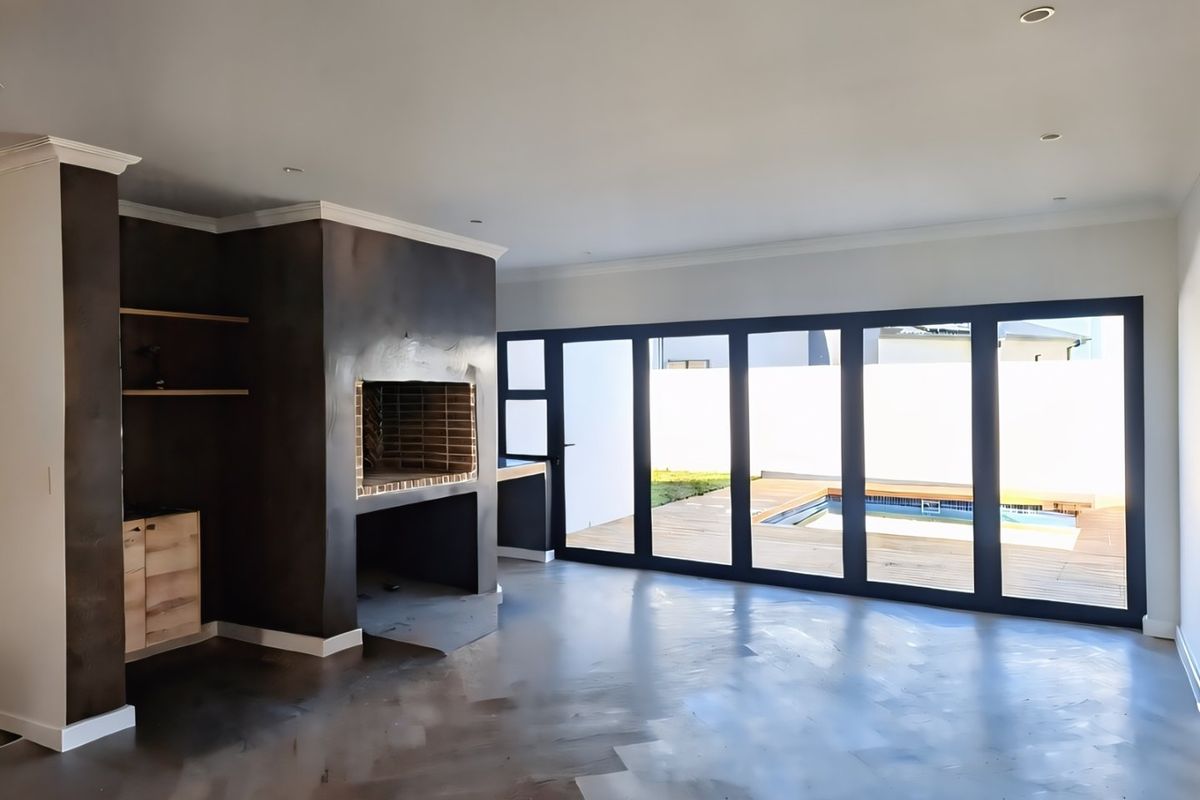 Spacious living area featuring a built-in fireplace, modern wooden flooring, and large bi-fold doors opening onto a deck with a swimming pool.