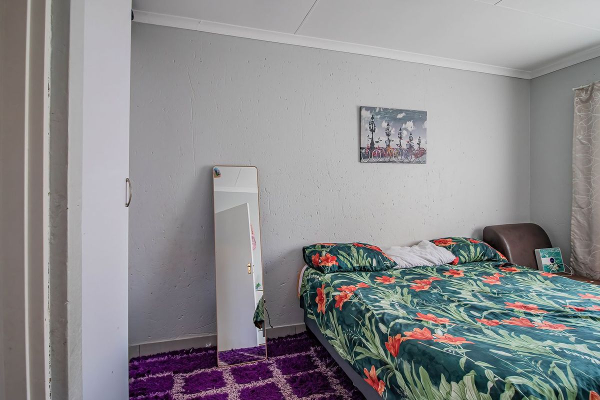 A functional bedroom featuring a built-in wardrobe and neutral wall finishes, providing a comfortable and practical living space.