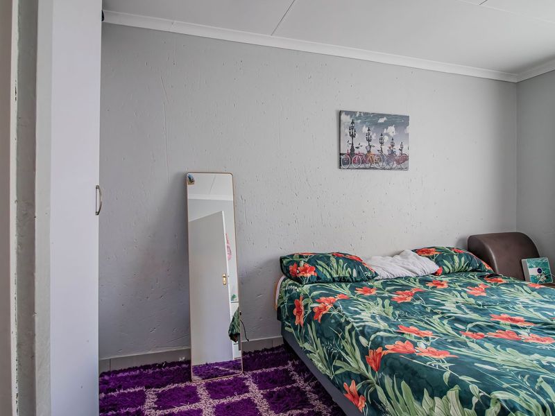 A functional bedroom featuring a built-in wardrobe and neutral wall finishes, providing a comfortable and practical living space.