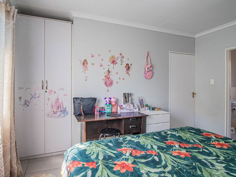 A bedroom featuring a built-in wardrobe and an adjoining en-suite bathroom with standard fixtures.