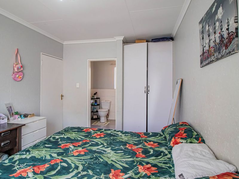 A bedroom featuring a built-in wardrobe and direct access to an en-suite bathroom, offering a functional layout with neutral wall finishes.