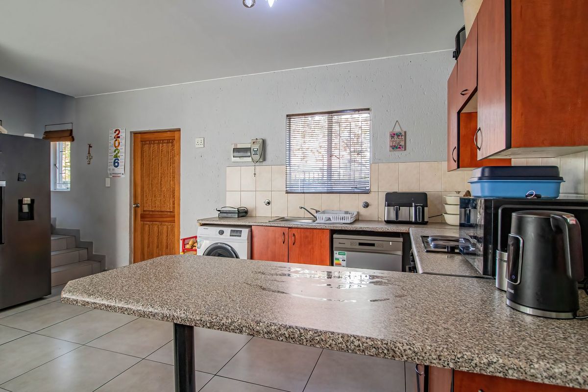 Functional kitchen featuring laminate countertops, tiled backsplash, built-in cabinetry, and integrated appliances, with direct access to adjacent living areas.