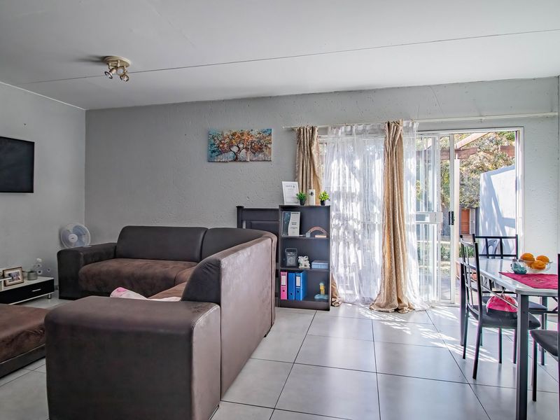 Open-plan living and dining area featuring tiled flooring and a sliding glass door providing access to the outdoor space.